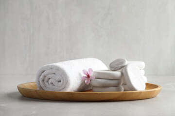 Spa stones, towel and fresia flower on light table