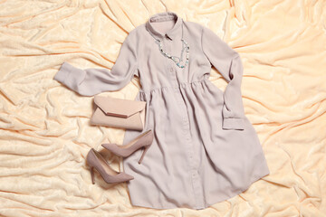 Flat lay composition with stylish grey dress on beige blanket