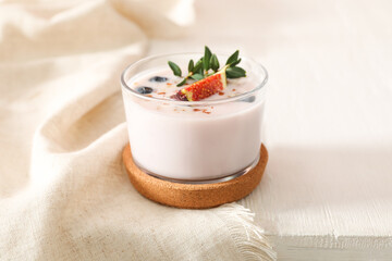 Delicious fig smoothie in glass on white wooden table