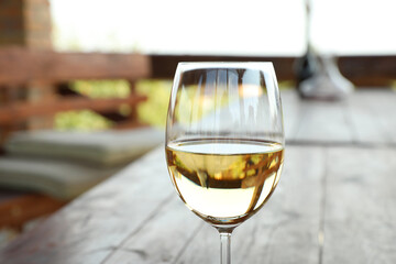 Glass of delicious white wine on blurred background, closeup. Space for text