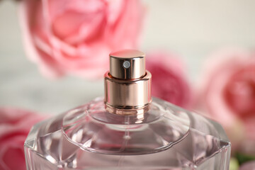 Bottle of perfume on blurred background, closeup