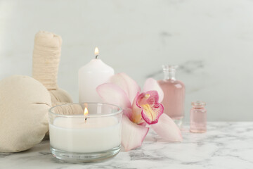 Fototapeta na wymiar Beautiful spa composition with candles and aroma oil on white marble table