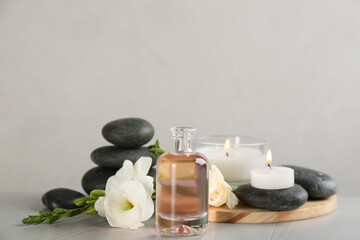 Fototapeta na wymiar Beautiful composition with essential oil, spa stones and candles on table