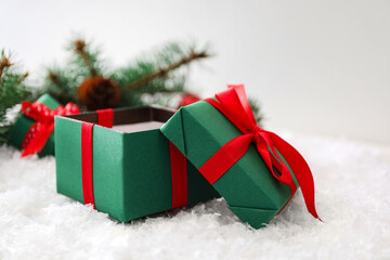 Open Christmas gift box with red bow on snow