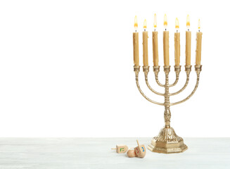 Golden menorah and Hanukkah dreidels with He, Gimel, Nun symbols on white background