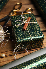 Composition with beautifully wrapped gift box on wooden table