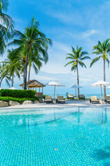 Fototapeta na wymiar Beautiful tropical beach and sea with umbrella and chair around swimming pool in hotel resort