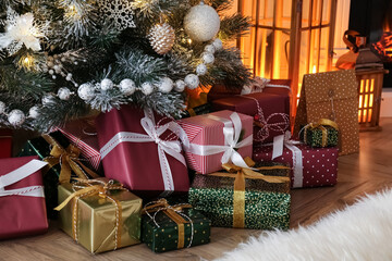 Fototapeta na wymiar Pile of gift boxes near beautiful Christmas tree indoors