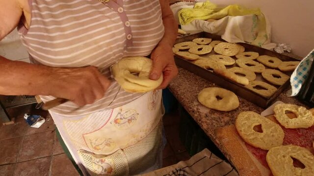 Cutting bread with the knife to make freselle, typical Southern Italian hard bread.