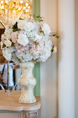  vase with artificial flowers in a light interior on a shelf near the mirror.