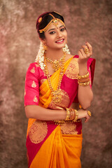 Fototapeta premium Beautiful smiling Indian bride with jewelry in studio shot.