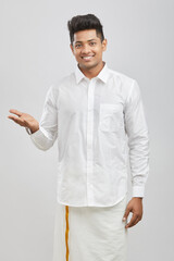 Portrait young happy south Indian man greeting in traditional dress.