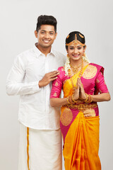Fototapeta na wymiar Attractive south Indian couple greeting namaste in traditional dress