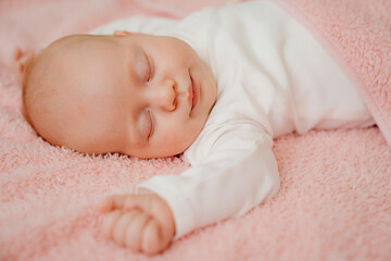 sleeping baby under the pink blanket. healthy sleep in newborns.