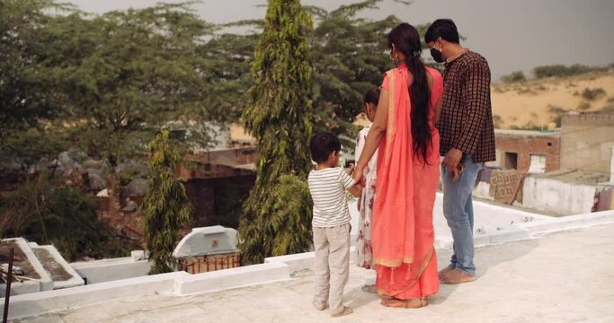 Slow-motion of parents and kids wearing protective face mask on terrace balcony roof of house building maintaining physical and social distancing due to coronavirus covid-19 new normal pandemic