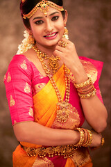 Obraz premium Beautiful smiling Indian bride with jewelry in studio shot.