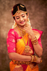 Obraz premium Beautiful smiling Indian bride with jewelry in studio shot.