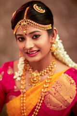 Beautiful smiling Indian bride with jewelry in studio shot.