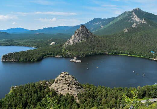 A large stone rock in the middle of a beautiful lake. Big stone rocks, beautiful mountains, pine trees. Beautiful views of the nature of Kazakhstan. Burabay, Kazakhstan.