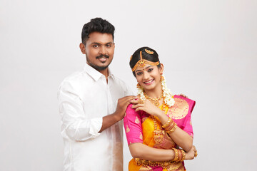Attractive happy south Indian couple in traditional dress, Studio shot.