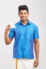 Young man holding business card in traditional dress.