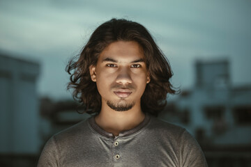 Obraz premium Young man portrait with long hair in evening light