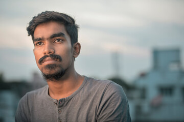 Fine art portrait of handsome young man looking at the light.