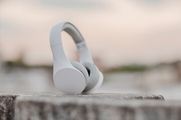 Headphones on concrete wall at evening light.