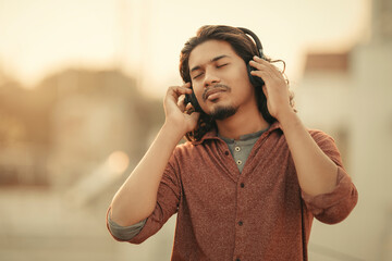 Young man listening music in outdoor.