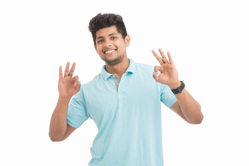 Happy Indian young man making super ok gesture isolated on white.