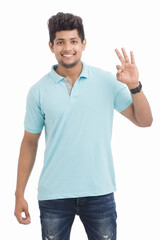 Fototapeta premium Happy Indian young man making super ok gesture isolated on white.