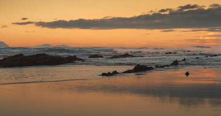 Beautiful sunset with waves in the sea and clouds in the background