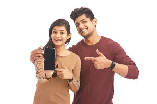 Beautiful happy young couple holding smart phone on white.