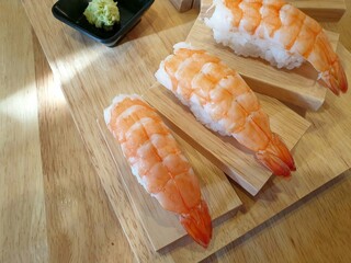 sushi on a bamboo mat on wooden table.