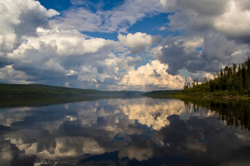 Paanajarvi lake with clouds reflecting on water surface. Near border of Finland and Russia.