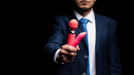 man in a suit is holding pink vibrators for sex