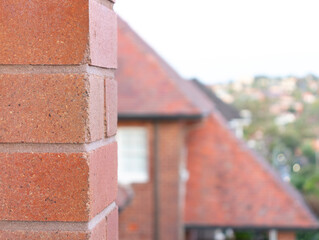 Naklejka premium Brick close up with houses in blurred background