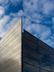 Fototapeta premium Modern building detail with reflection of cloudy sky