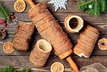 Delicacy from Trdelnik dough. Dough baked on a skewer and charcoal with sugar, cinnamon and vanilla. Christmas sweets, street food. Czech and Moravian cuisine.