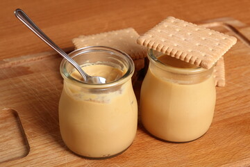 Milk pudding dessert in jar with cookies
