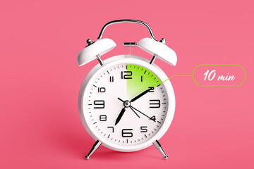 Alarm clock with timer for 10 minutes on color background. Time management concept