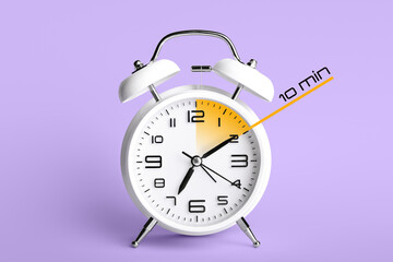 Alarm clock with timer for 10 minutes on color background. Time management concept