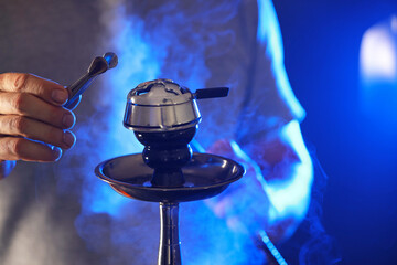 Man with hookah tweezer, closeup