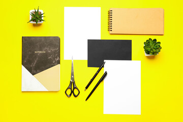 Composition with blank paper sheets and stationary on color background