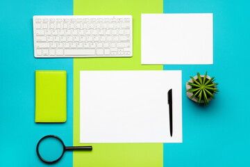 Composition with blank paper sheets and stationary on color background