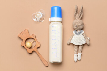 Bottle of milk for baby and accessories on color background