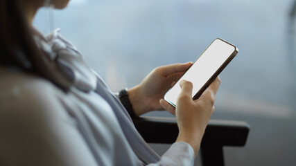 Businesswoman hands using smartphone while relaxed sitting on arm chair