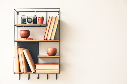 Shelf with books and decor on white wall
