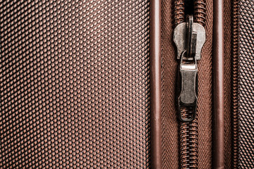 Vintage Unzipped Zipper and silver shining lock on dark brown background with blank empty space. Vintage design. Close up. Copy space