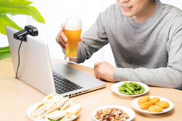 自宅でオンライン飲み会をしている男性